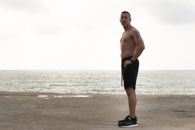 Masculino guapo joven descansando en la playa