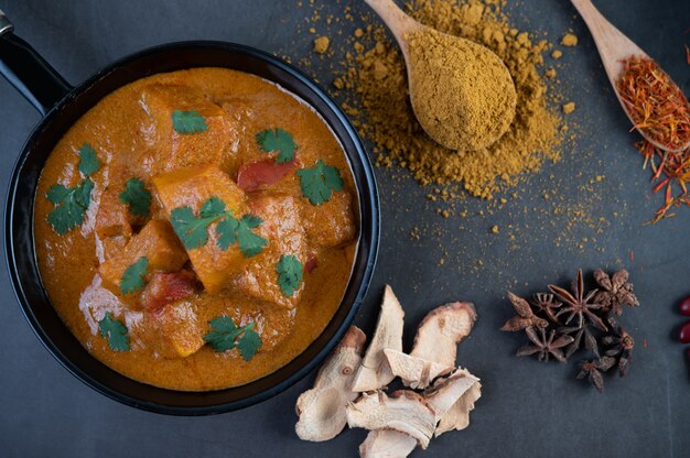 Foto gratuita massaman curry en una sartén con especias en el piso de cemento