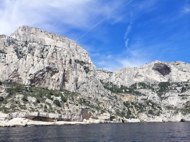 Massif des Calanques rodeado por el mar bajo un cielo azul y la luz del sol en Francia