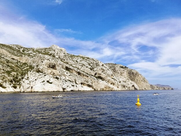 Massif des Calanques rodeado por el mar bajo un cielo azul y la luz del sol en Marsella en Francia