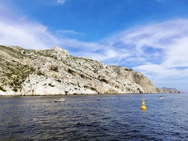 Massif des Calanques rodeado por el mar bajo un cielo azul y la luz del sol en Marsella en Francia