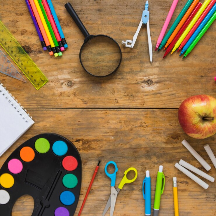Foto gratuito material escolar y manzana en círculo