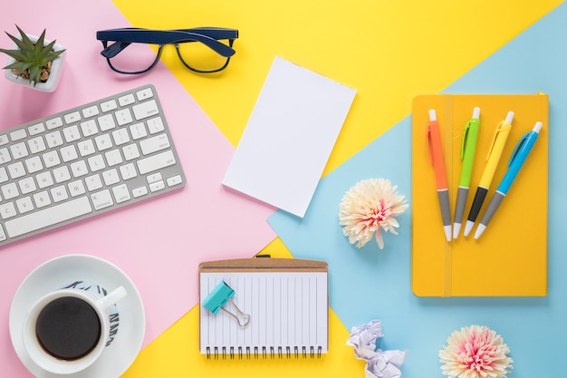 Material de oficina; Taza de café y teclado en lugar de trabajo colorido