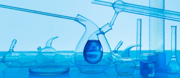 Material de vidrio de laboratorio sobre fondo azul.