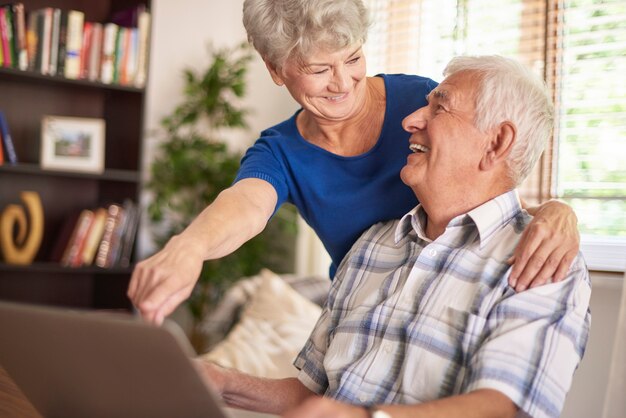 Matrimonio de ancianos usando su computadora portátil juntos