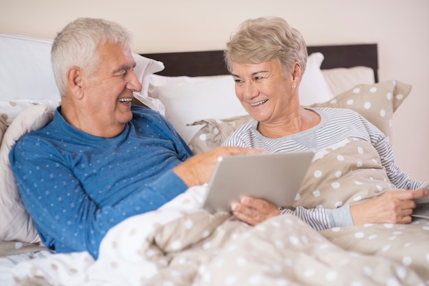 Matrimonio senior alegre usando una tableta juntos