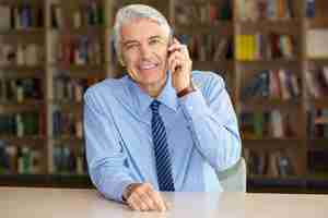 Foto gratuita mayor sonriente hombre de negocios hablando por teléfono móvil