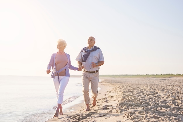 Mayores vitales en la playa. Pareja senior en la playa, la jubilación y el concepto de vacaciones de verano