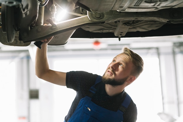 Mecánico de automóviles buscando la nave del automóvil