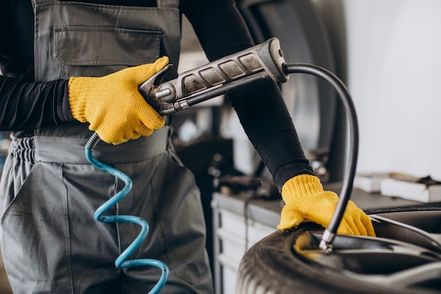 Mecánico de automóviles cambiando las ruedas en el coche