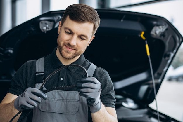 Foto gratuita mecánico de automóviles comprobando la correa de distribución