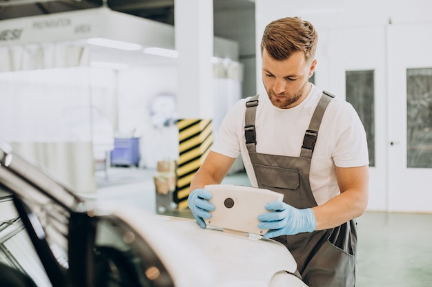 Foto gratuita mecánico de automóviles escaneo de pintura de automóviles con equipo especial