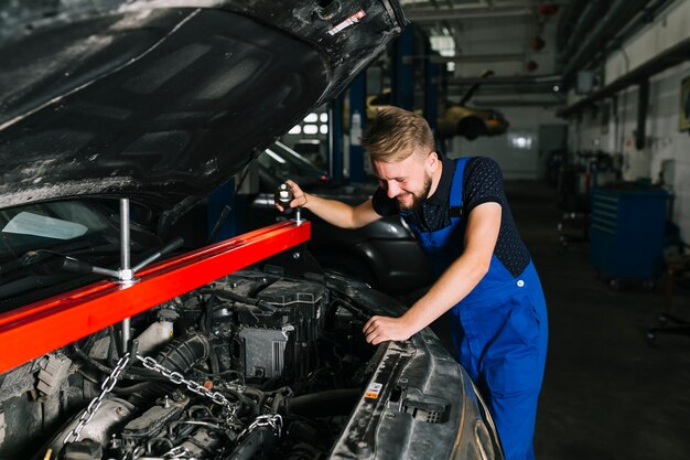 Mecánico de automóviles levantando el motor del automóvil