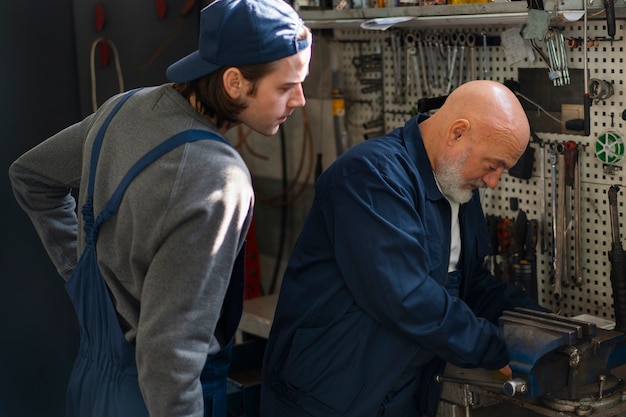 Foto gratuita mecánico de automóviles masculino que trabaja en el taller de reparación de automóviles