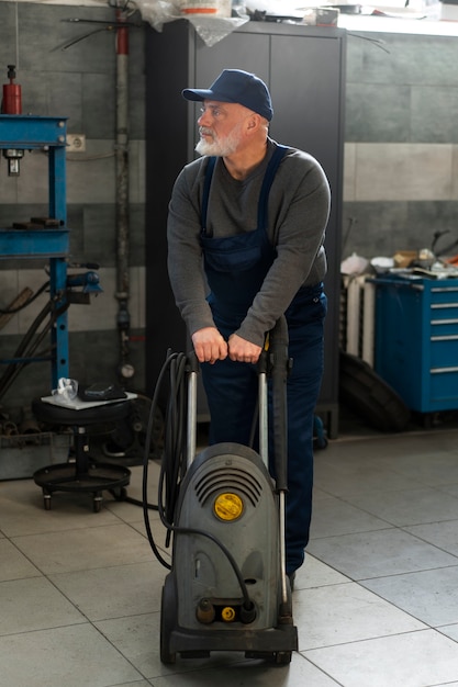 Foto gratuita mecánico de automóviles masculino que trabaja en el taller de reparación de automóviles