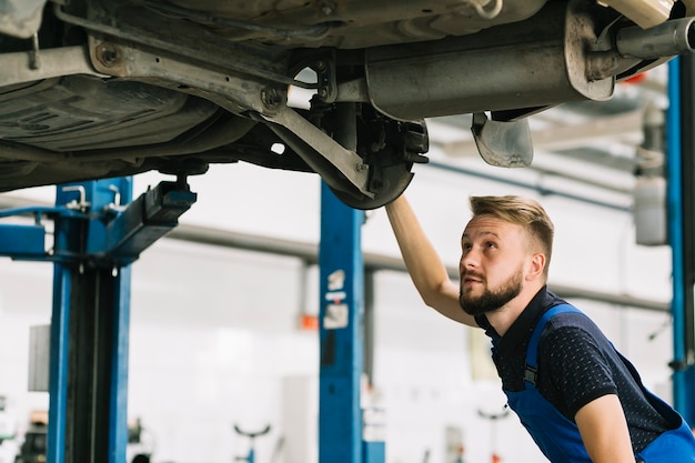 Mecánico de automóviles que mira la sentina del coche