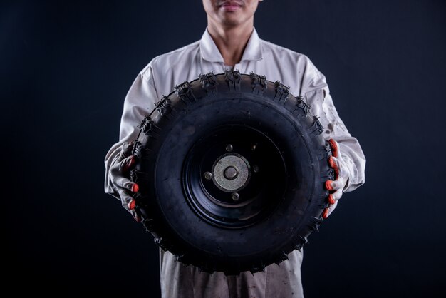 Mecánico de automóviles con un soporte uniforme blanco con llave