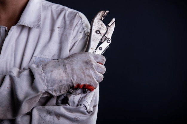 Foto gratuita mecánico de automóviles con un soporte uniforme blanco con llave