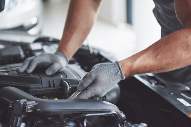 Mecánico de automóviles trabajando en garaje. Servicio de reparación.