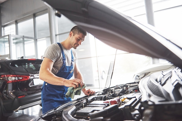 Mecánico de automóviles trabajando en garaje. Servicio de reparación.