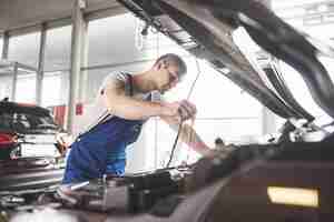 Foto gratuita mecánico de automóviles trabajando en garaje. servicio de reparación.