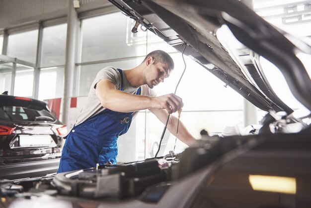 Mecánico de automóviles trabajando en garaje. Servicio de reparación.