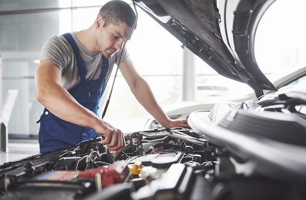 Mecánico de automóviles trabajando en garaje. Servicio de reparación.