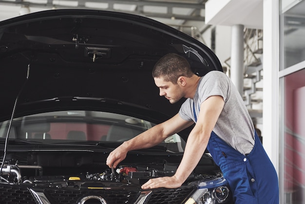 Mecánico de automóviles trabajando en garaje. Servicio de reparación.