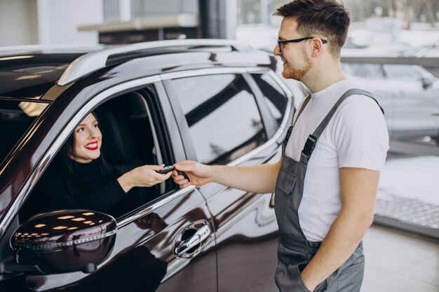 Mecánico con cliente en estación de servicio de automóviles