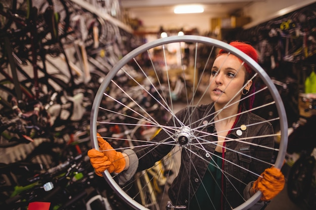 Mecánico examen de una rueda de bicicleta