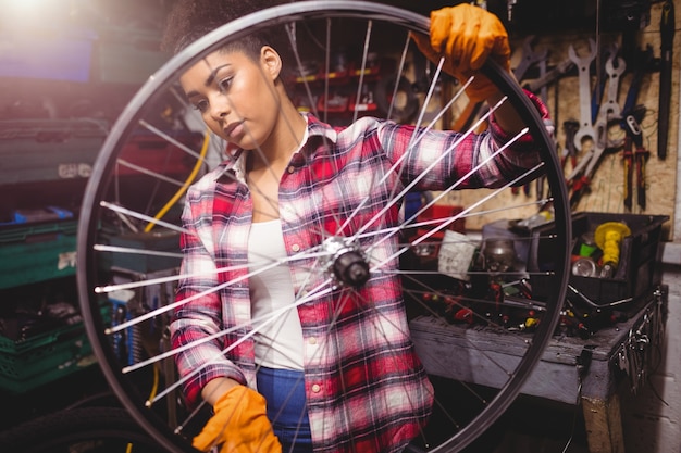 Mecánico examen de una rueda de bicicleta