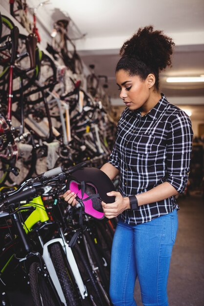 Mecánico examinar un casco de bicicleta