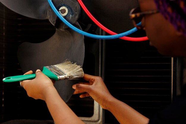 Mecánico experimentado quitando la capa de suciedad del ventilador para evitar dañar el sistema de ventilación.