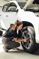 Foto gratuita mecánico femenino que fija las ruedas del coche