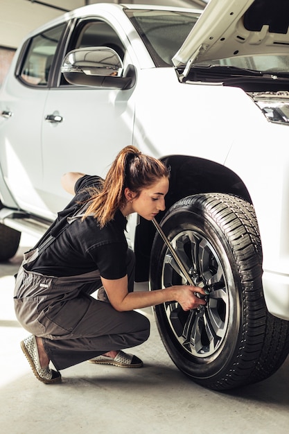 Mecánico femenino que fija las ruedas del coche