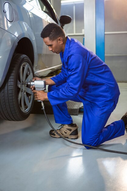 Mecánico de la fijación de un neumático de coche