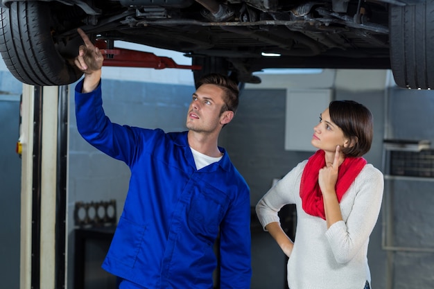 Mecánico que muestra al cliente el problema con el coche