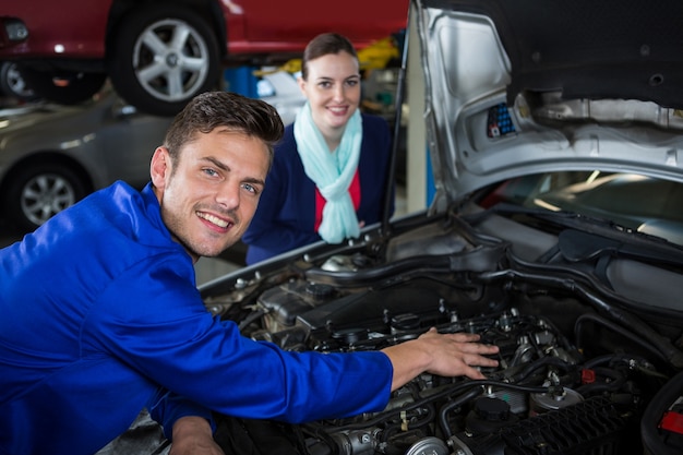 Foto gratuita mecánico que muestra al cliente el problema con el coche