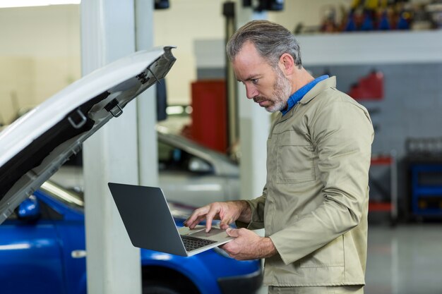 Mecánico que usa la computadora portátil