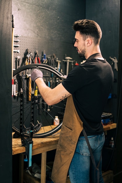 Foto gratuita mecánico reparando una bicicleta