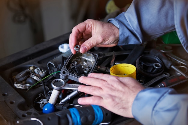 Mecánico reparando un coche en el taller.