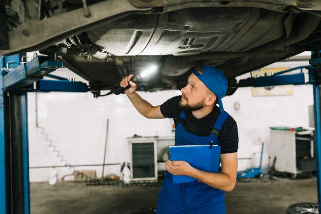 Mecánico revisando la parte inferior del auto