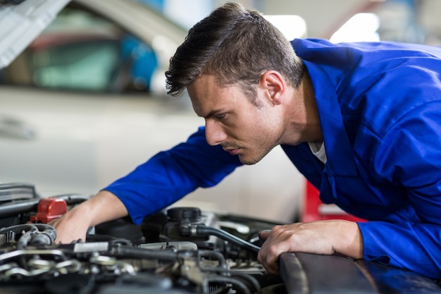 Foto gratuita mecánico de servicio a un motor de coche