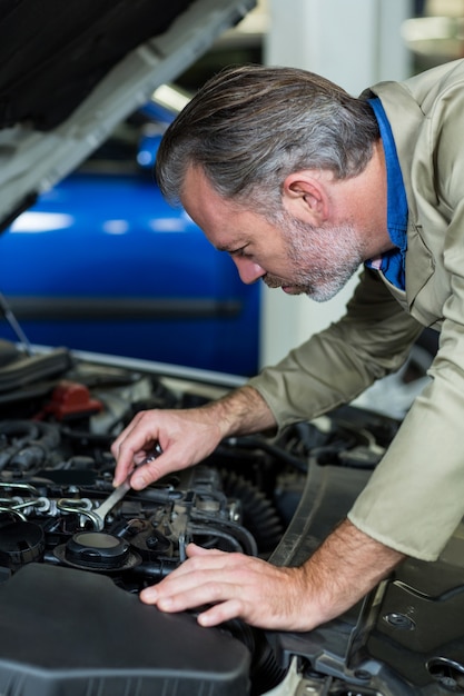 Foto gratuita mecánico de servicio a un motor de coche