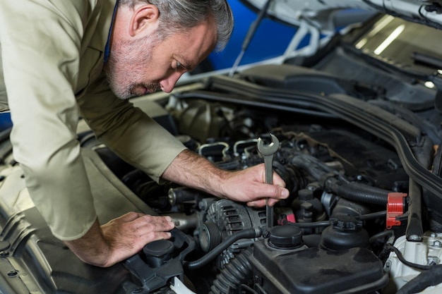 Foto gratuita mecánico de servicio a un motor de coche