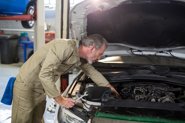 Foto gratuita mecánico de servicio a un motor de coche