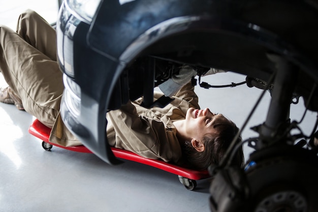 Mecánico de sexo femenino que repara un coche