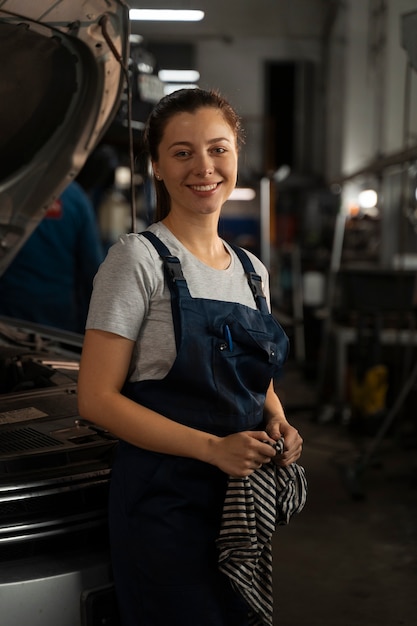 Mecánico de sexo femenino que trabaja en la tienda en un coche