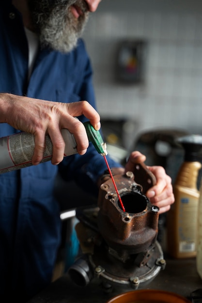 Mecánico de sexo masculino que trabaja en el coche en el taller de reparación de automóviles