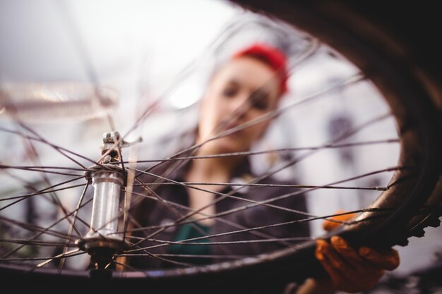 Mecánico sosteniendo una rueda de bicicleta